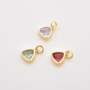 Macro view of triangular zircon pendants in lavender, blue, and rose with gold plating