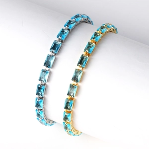 Detail view of gold and silver bracelets featuring rectangular cut blue zircon stones