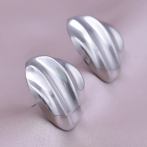 Macro shot of silver 304 stainless steel earrings with layered wavy shell texture