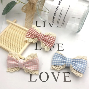 Detailed view of plaid fabric bows with lace edges in red, pink, and blue patterns