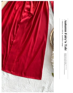 Close-up of shiny red satin robe featuring a smooth silk-like texture and matching waist tie