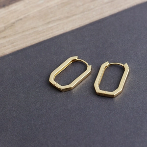 Detailed view of square geometric gold hoop earrings with mirror polished finish