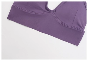 Close-up of seamless dark purple sports bra featuring ribbed hem and U-neck detail