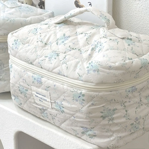 Detailansicht der gesteppten Kosmetiktasche mit blauen Blumen und weicher Baumwolle