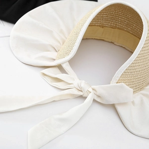 Wide brim straw sun hat with a large white satin bow detail for elegant summer sun protection
