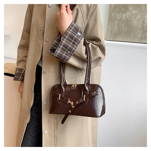 Detail of a brown PU leather vintage handbag with golden buckles and metal hardware
