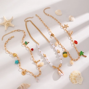 Detailed view of bohemian gold necklaces with pearl, shell, and starfish charms