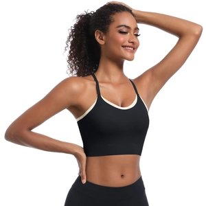 Detail view of black sports bra with cream contrast trim and thin shoulder straps