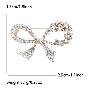 Elegant gold bow brooch with rhinestones, 4.5cm width, weight details on white background