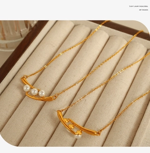 Détail macro de colliers de perles dorées élégants dans un coffret à bijoux en velours beige
