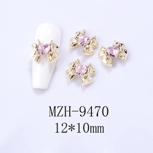 Detail of bow nail charms with pink heart rhinestones in 12x10mm size on white nails