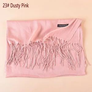 Close-up of dusky pink cashmere scarf showing fine tassel fringe and soft fabric texture