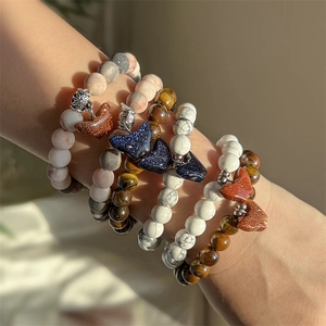 Close-up of beaded bracelets with natural agate tiger eye stones and butterfly charms