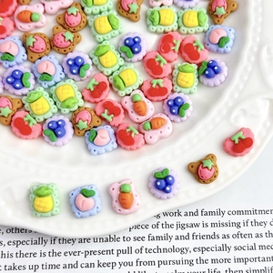 Assorted fruit and cookie resin charms for DIY crafts and nail art on a decorative plate