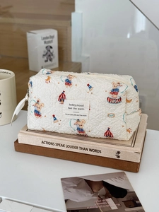 Quilted cotton makeup bag with cute circus bear print on warm domestic background