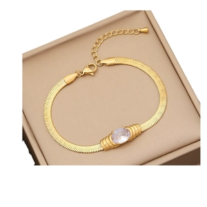 Golden snake chain bracelet with oval clear gemstone in beige jewelry box