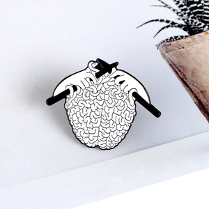 Creative brain knitting enamel pin with hands and needles design in black and white finish