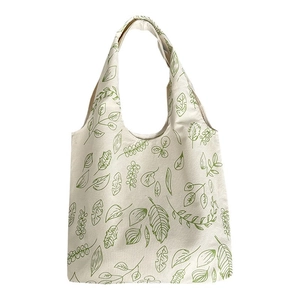 White canvas tote bag featuring green leaf prints and large capacity shoulder straps
