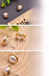 Macro detail of 12mm natural freshwater pearl earrings with gold wire wrap design