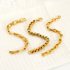 Three gold hip-hop stainless steel bracelets in different link styles on white fabric