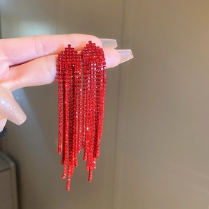 Detail shot of long red rhinestone fringe earrings with shimmering tassels for women
