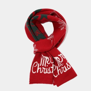 Detail of red and green knit scarf with snowflake patterns and Merry Christmas text