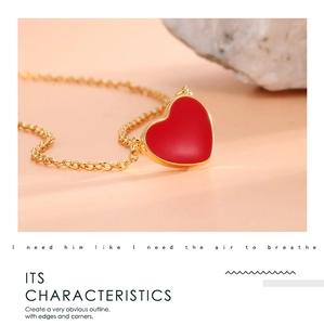Detailed macro view of the red heart-shaped pendant with an elegant golden metal chain