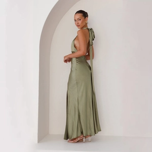 Detail of sage green satin halter dress featuring elegant back bow and side slit