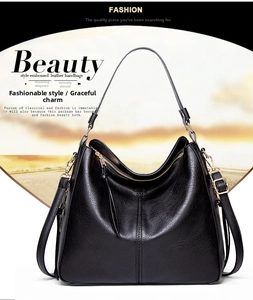 Close-up of black embossed leather handbag with vertical stitching and gold hardware details