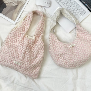 Flat lay of pink mesh tote and crescent bag with white daisy lace embroidery detailing