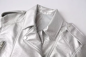 Detail of silver metallic biker jacket featuring lapels, zippers, and faux leather texture