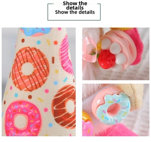 Detail of Christmas gnome plush fabric with resin donut and strawberry accessories