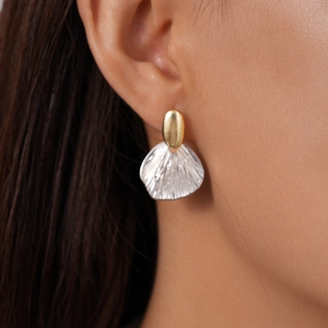 Close-up of geometric oval shell earrings in gold and silver finish on a model