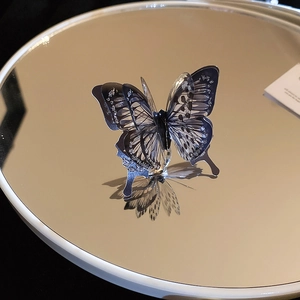 Macro view of blue butterfly layered ring showing glitter texture and mirror reflection
