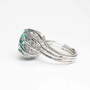 Exquisite Paraiba blue oval gemstone ring with diamond-encrusted silver lotus cage setting