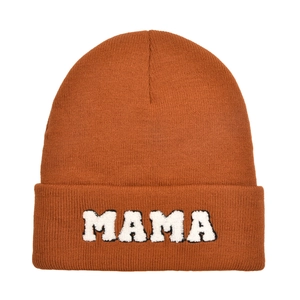 Macro shot of MAMA letter patch and orange knitted texture on winter beanie cap