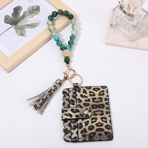 Detail of leopard print card holder with turquoise wood beads and tassel wristlet keychain
