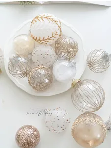 Detail of elegant champagne and white Christmas ornaments with leaf patterns and feather fill
