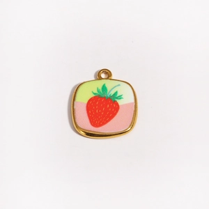 Détail d'un pendentif fraise en or 18 carats avec émail rouge et feuilles vertes ciselées