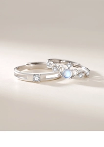 Detail of silver couple rings with moonstone crown design and geometric diamond men's band
