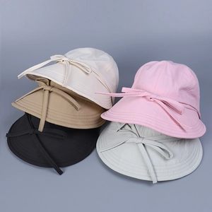 Detail of five nylon sun hats with ribbon bows in beige, khaki, black, pink and grey