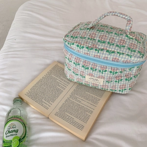 Detail of quilted cotton cosmetic bag with blue gingham and pink tulip floral patterns