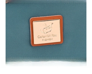 Detail of teal nylon fabric texture with brand metal logo and brown leather base