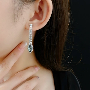 Elegant silver tassel earrings with sparkling rhinestones and a deep blue teardrop gemstone