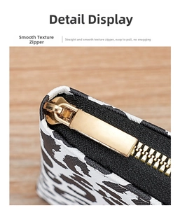 Detail view of smooth golden metal zipper on black and white animal print wallet