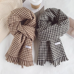 Close-up of wool blended houndstooth scarves with fringe detail and soft texture