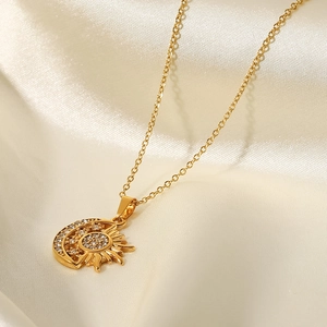 Macro shot of 18k gold plated sun and moon pendant with white cubic zirconia crystals