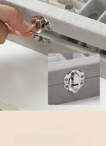 Detail view of the silver metal latch and soft gray velvet finish on the jewelry box
