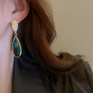 Vintage emerald green teardrop earrings with gold textured studs on model