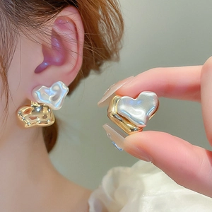 Irregular heart stud earrings in gold and pearl white finish with lava texture design